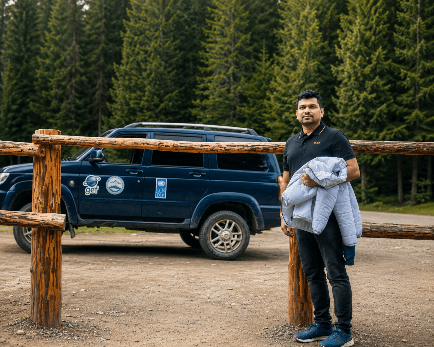Manas Majhi in a forest in Kazakhstan next to a UNDP Land Cruiser
