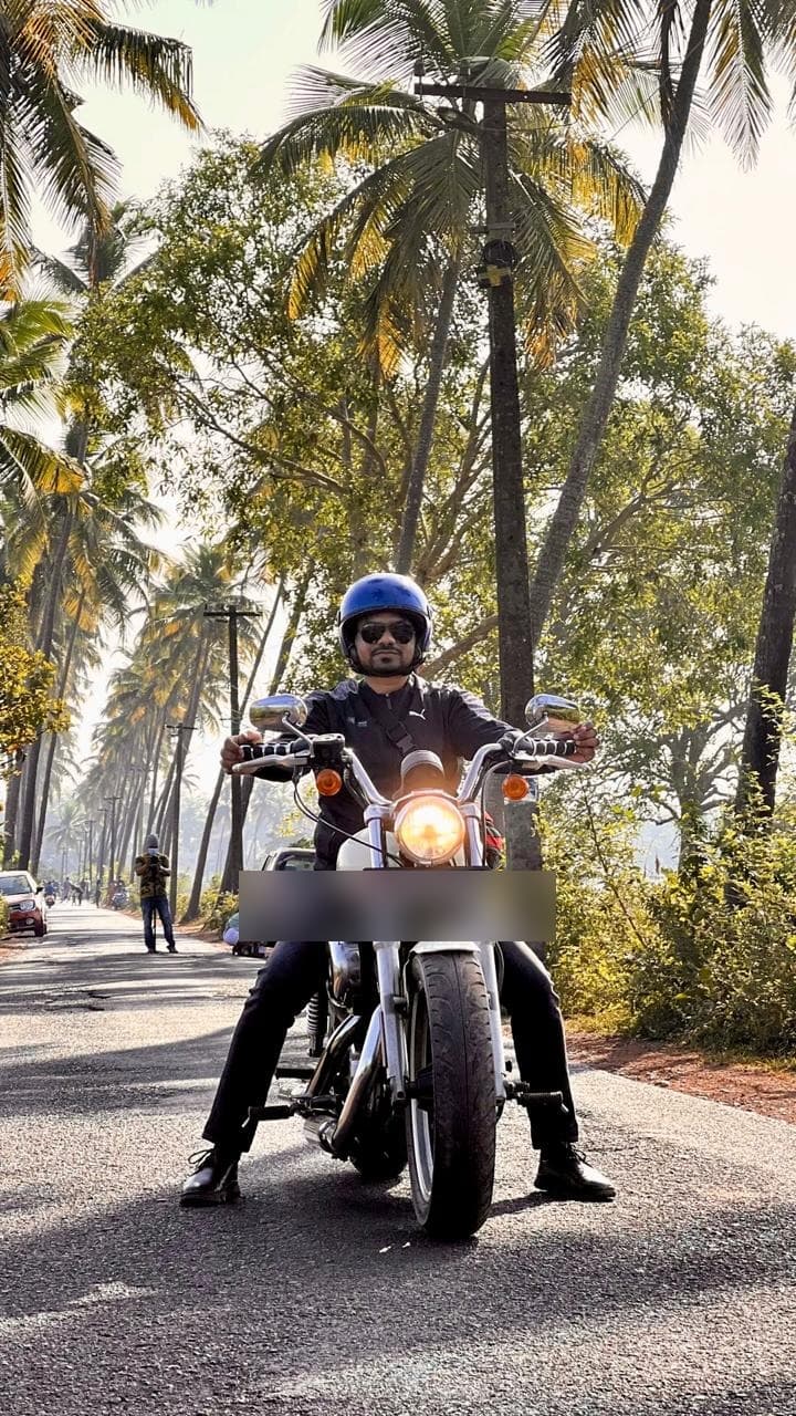 Manas Majhi on a motorcycle on a palm-lined road in Goa