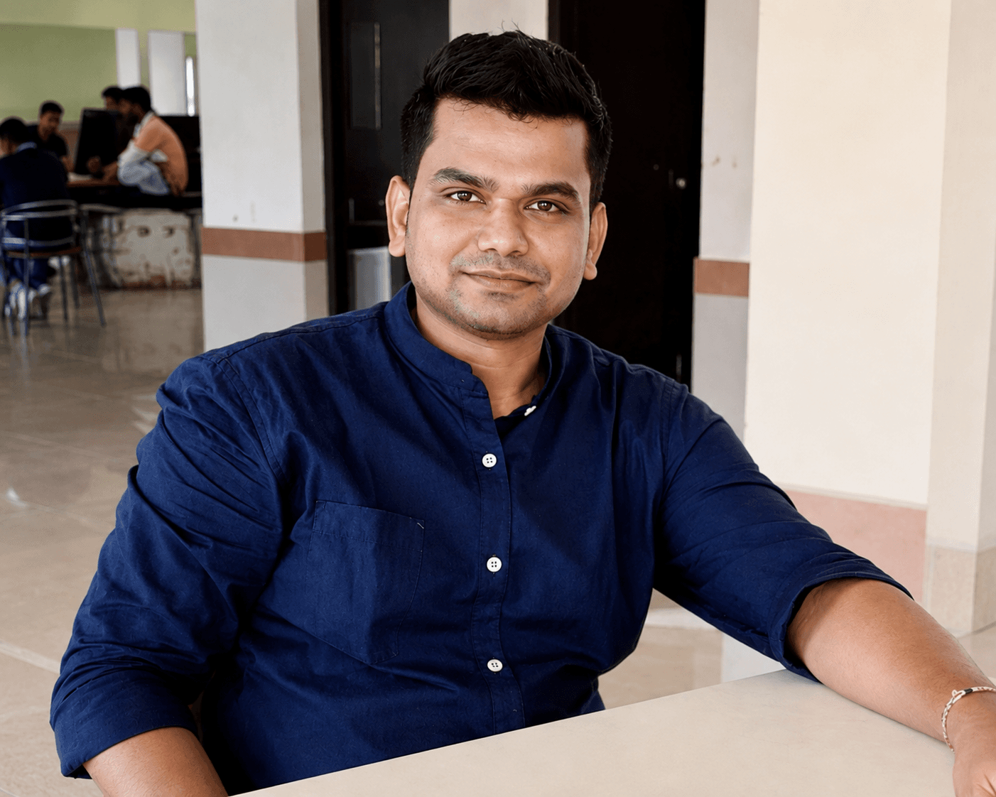 Manas Majhi seated at a table in a casual indoor setting