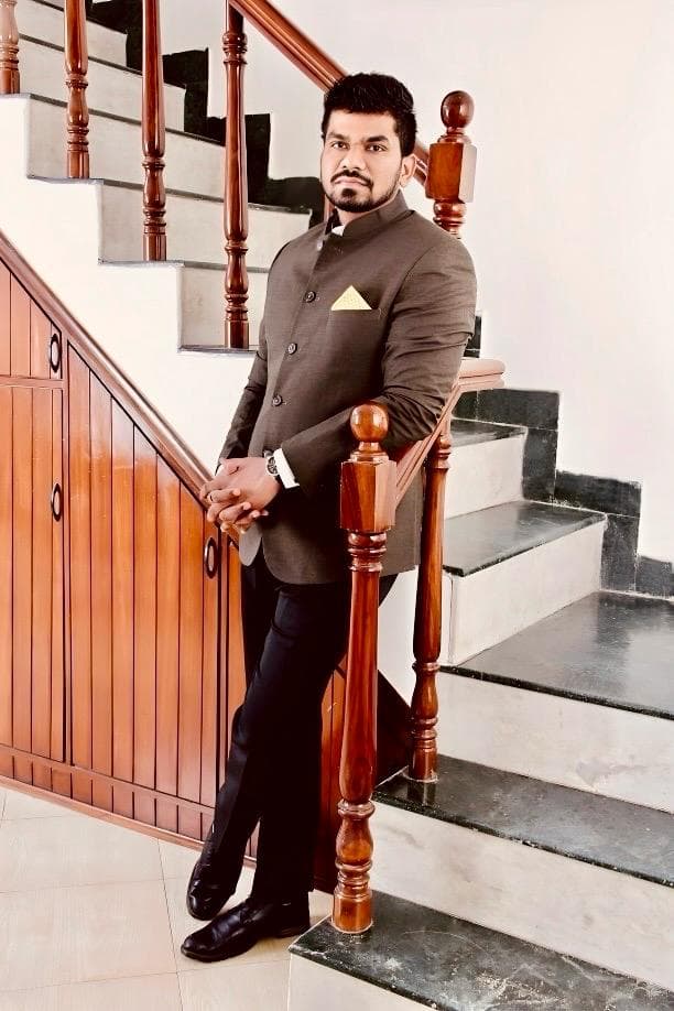 Manas Majhi in a Nehru jacket on a staircase